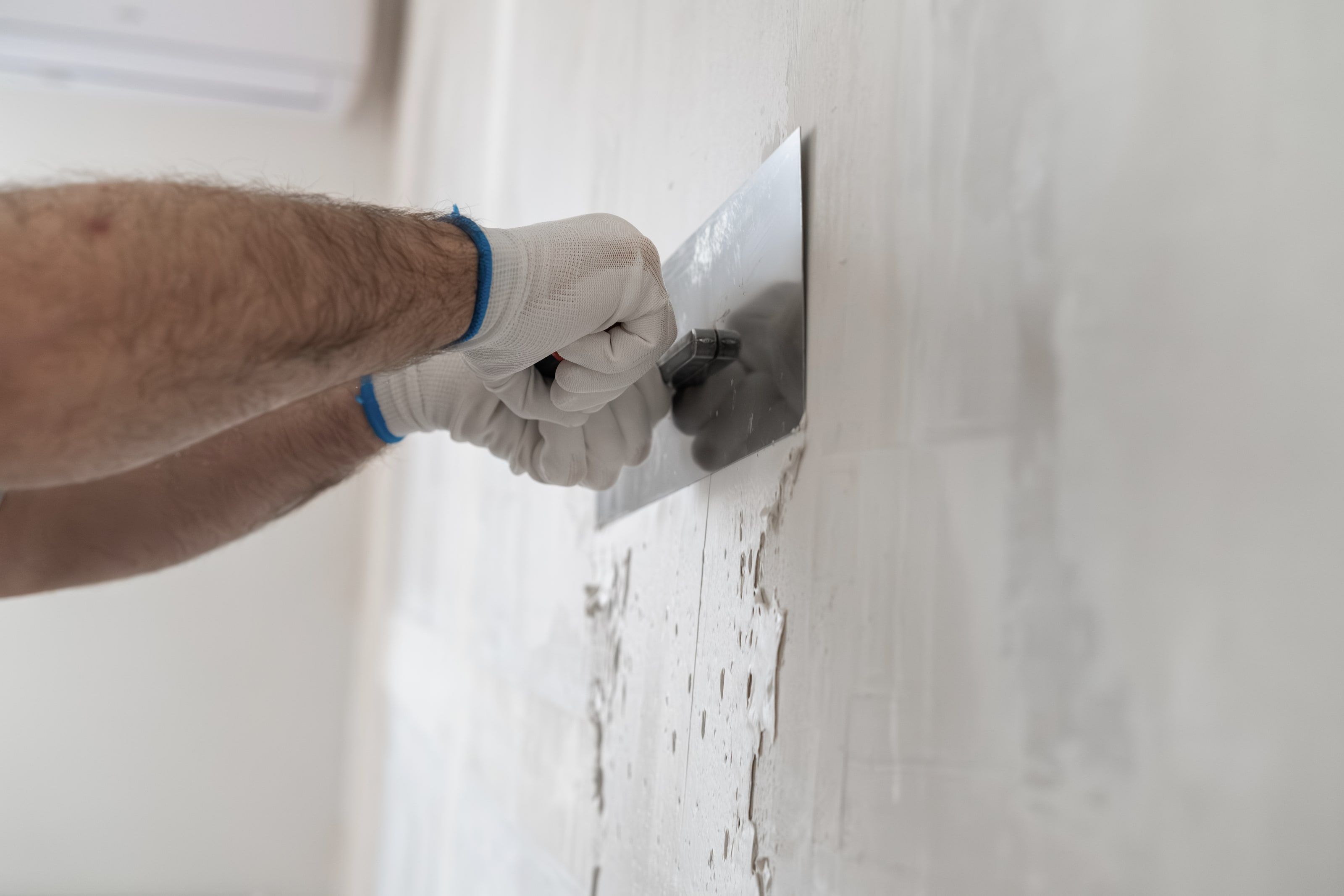 Glätten einer frisch verputzten Wand mit der Edelstahlkelle